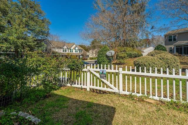 view of yard featuring a gate, a residential view, and fence