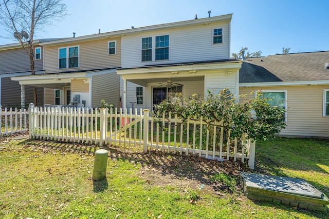 back of house featuring a fenced front yard, a lawn, and a ceiling fan