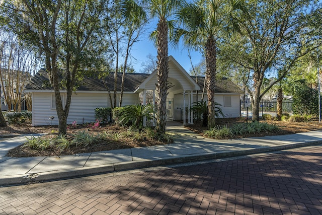 view of front of home featuring roof with shingles and fence