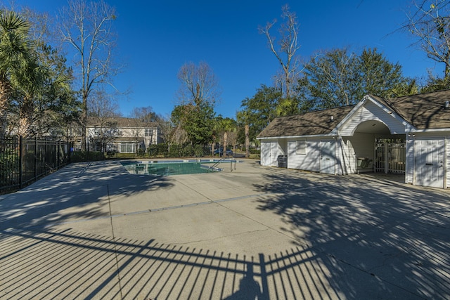 pool with a patio area and fence