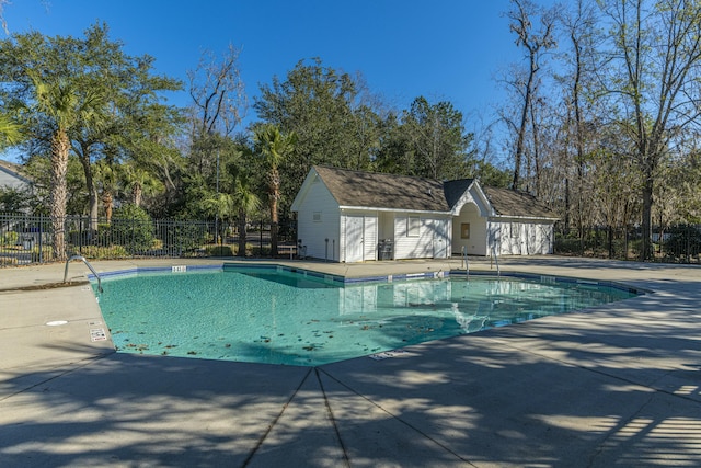 pool featuring a patio area, an outdoor structure, and fence