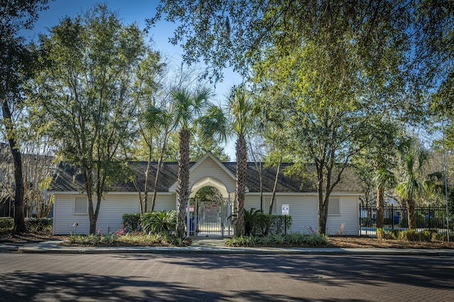 ranch-style home with a gate, a shingled roof, and fence