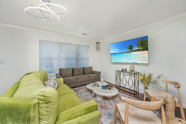 living room featuring visible vents, baseboards, wood finished floors, and crown molding