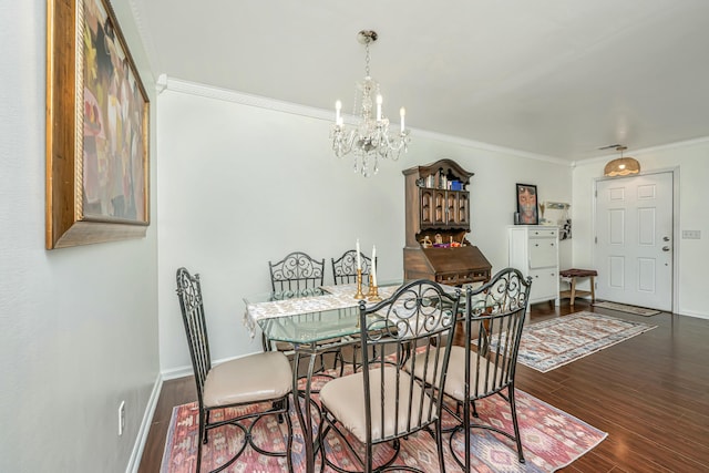 dining space featuring an inviting chandelier, crown molding, wood finished floors, and baseboards