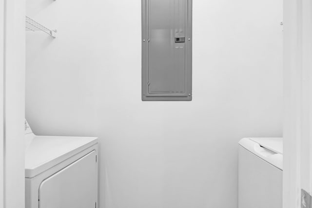 washroom featuring electric panel and washer and clothes dryer