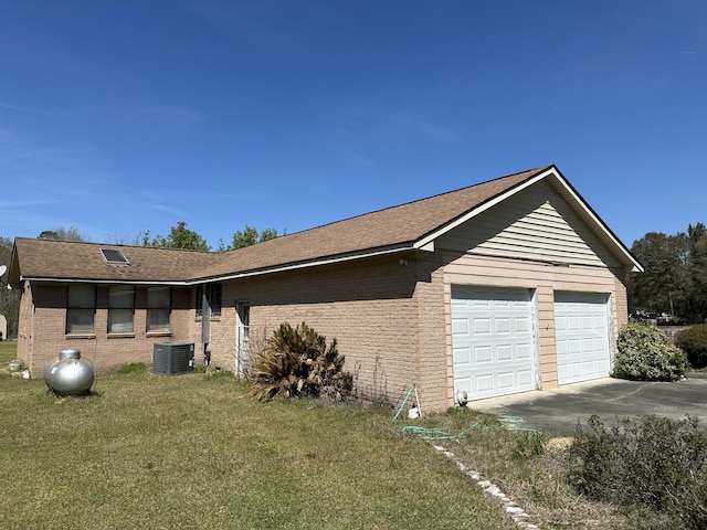 7819 Bells Hwy, Ruffin, SC 29475 - view of side of property with central air condition unit, driveway, brick siding, a garage, and a yard