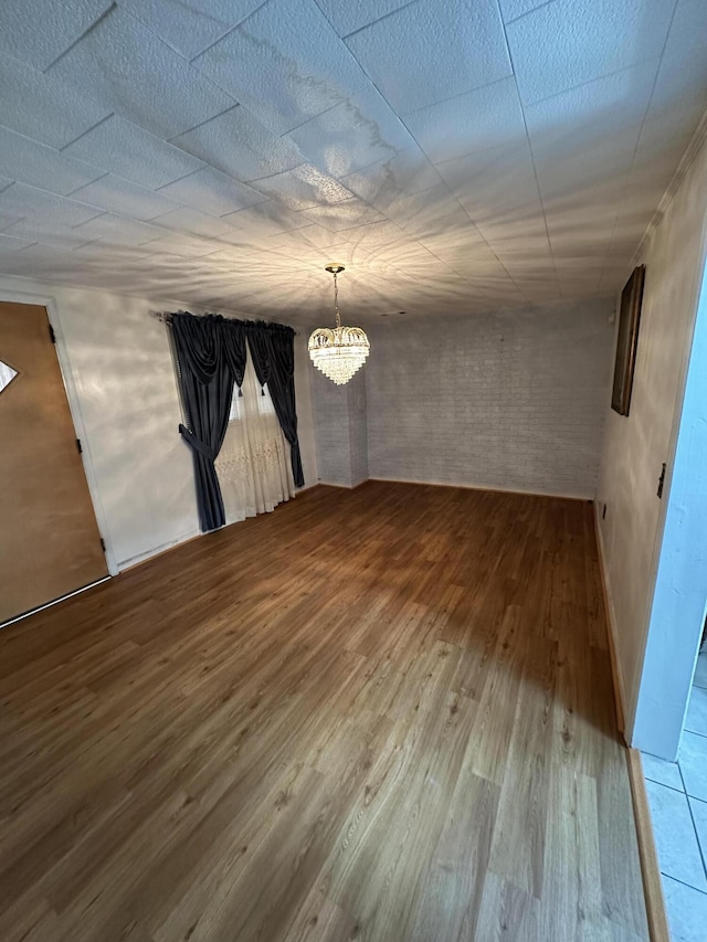 7819 Bells Hwy, Ruffin, SC 29475 - unfurnished room featuring an inviting chandelier, brick wall, and wood finished floors