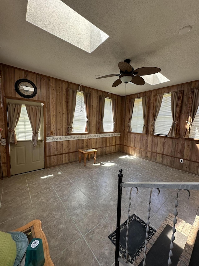 7819 Bells Hwy, Ruffin, SC 29475 - interior space featuring a ceiling fan, a skylight, a healthy amount of sunlight, and wood walls
