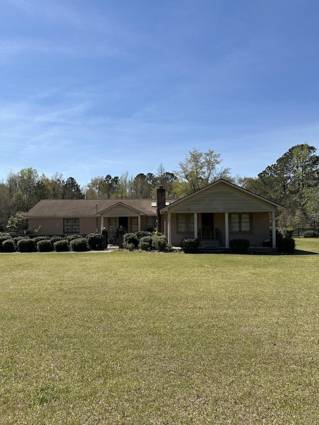 7819 Bells Hwy, Ruffin, SC 29475 - view of front of house with a chimney, a front yard, and covered porch