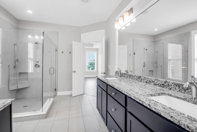 bathroom featuring tile patterned flooring, vanity, and walk in shower