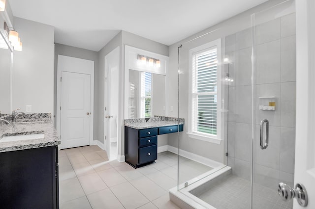 bathroom with vanity, plenty of natural light, tile patterned floors, and walk in shower