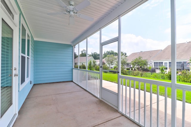 unfurnished sunroom with ceiling fan