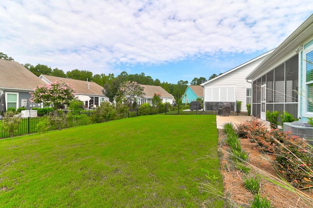 view of yard featuring a patio area, a sunroom, and central air condition unit