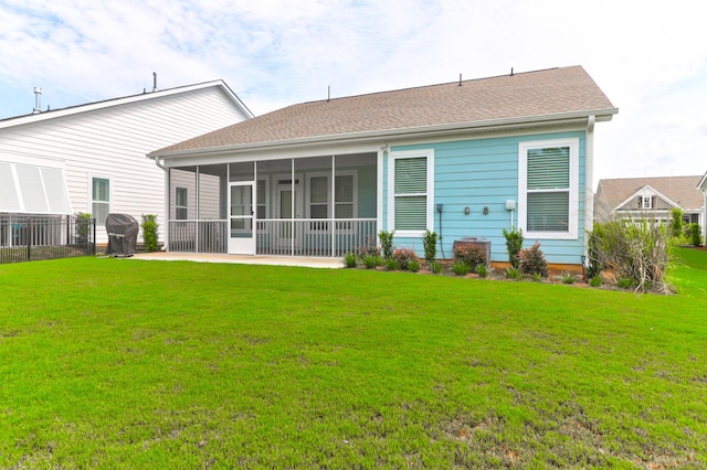 back of house featuring a sunroom and a lawn