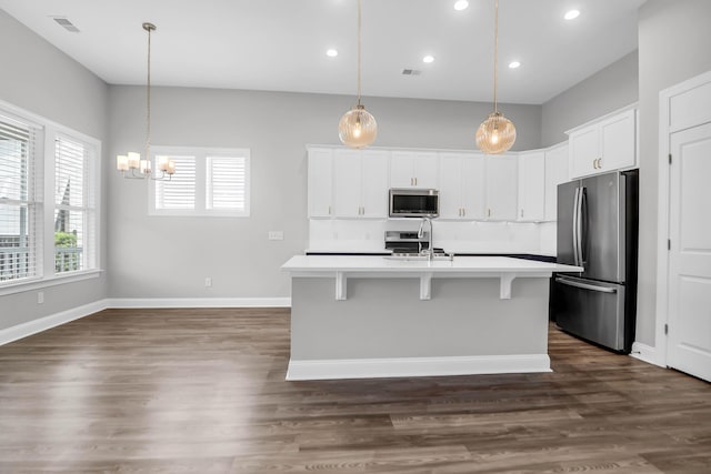 kitchen featuring sink, a center island with sink, appliances with stainless steel finishes, pendant lighting, and white cabinets