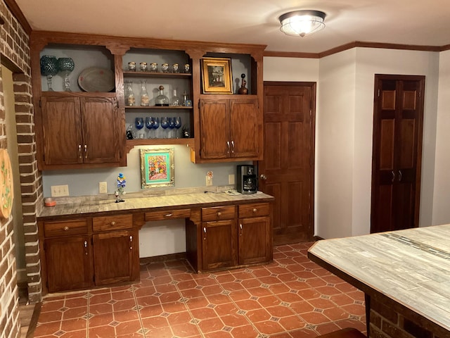 306 Park St, Saint George, SC 29477 - kitchen with open shelves, light countertops, tile patterned floors, brown cabinetry, and crown molding