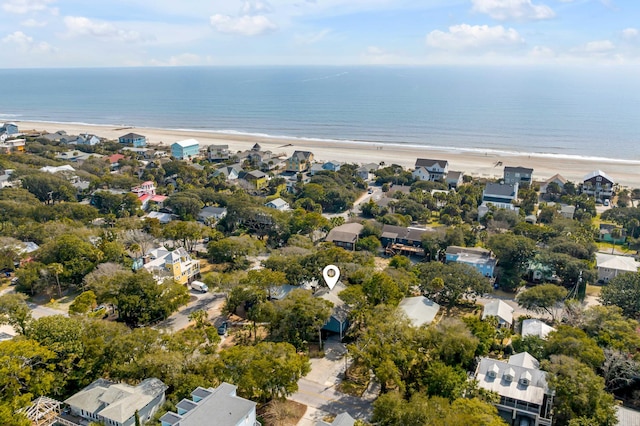 drone / aerial view featuring a view of the beach, a water view, and a residential view