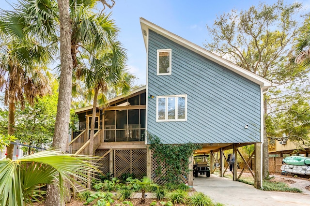 exterior space featuring a carport, concrete driveway, and a sunroom