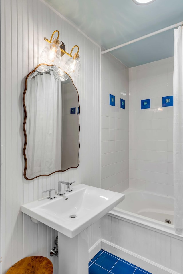 bathroom with tile patterned flooring, shower / bath combo, and a sink