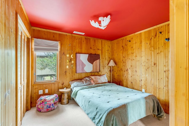 carpeted bedroom featuring wood walls and visible vents