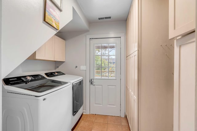 laundry room with cabinet space, light tile patterned floors, visible vents, and washer and clothes dryer