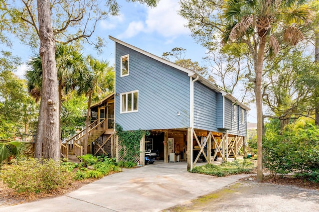 view of front of house featuring driveway, stairs, and a carport