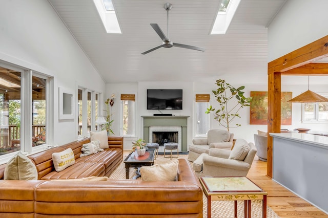 living area featuring a healthy amount of sunlight, a skylight, and a brick fireplace