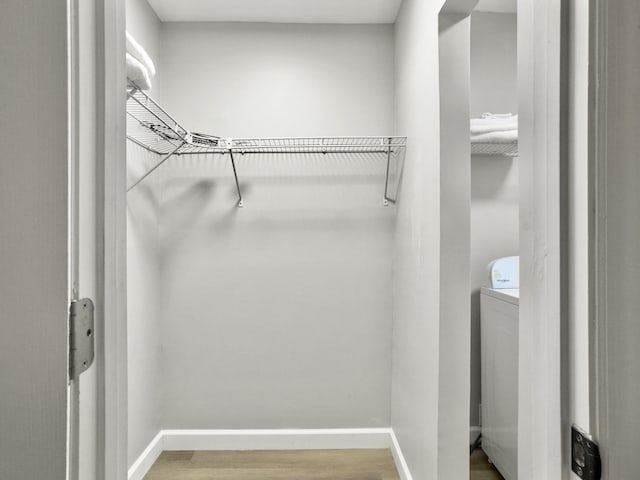 walk in closet featuring hardwood / wood-style flooring and washer / dryer