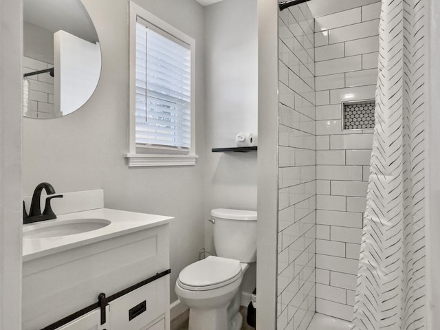 bathroom with vanity, toilet, and a tile shower