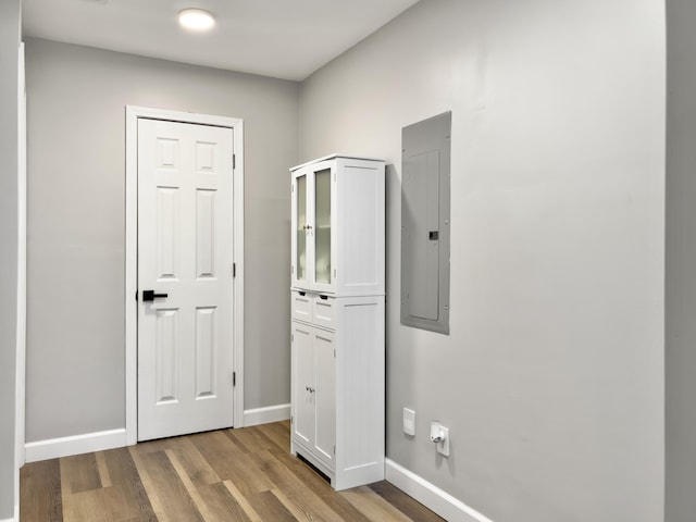 hallway with electric panel and light wood-type flooring