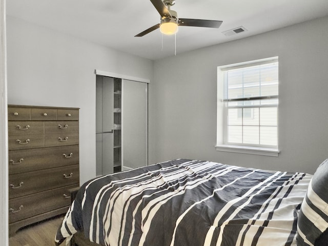 bedroom featuring hardwood / wood-style flooring, ceiling fan, and a closet