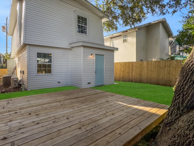 deck with a yard and central AC unit