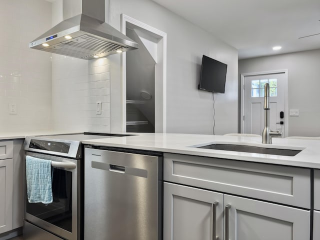 kitchen with sink, dishwasher, stove, island exhaust hood, and backsplash