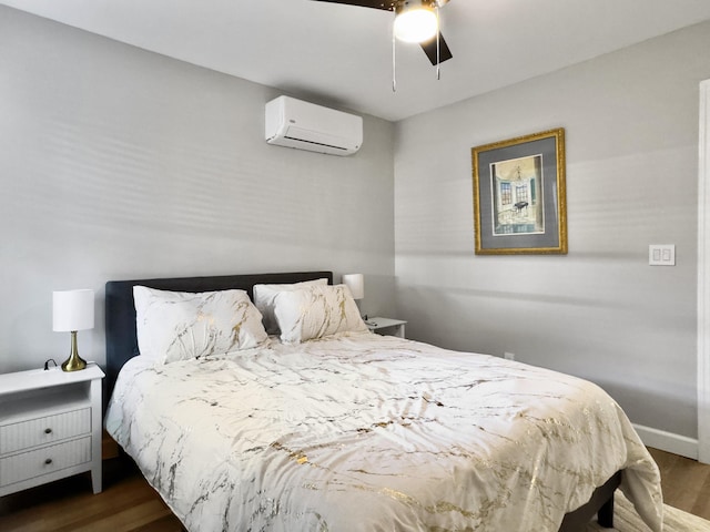 bedroom with dark wood-type flooring, an AC wall unit, and ceiling fan