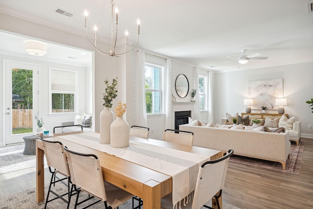 770 Opal Wing St, Moncks Corner, SC 29461 - dining room featuring wood finished floors, crown molding, a glass covered fireplace, ceiling fan, and baseboards
