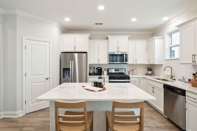770 Opal Wing St, Moncks Corner, SC 29461 - kitchen with appliances with stainless steel finishes, a sink, white cabinetry, decorative backsplash, and light wood-type flooring
