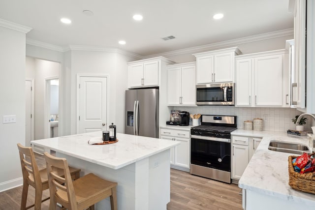 770 Opal Wing St, Moncks Corner, SC 29461 - kitchen featuring stainless steel appliances, a sink, a center island, white cabinets, and crown molding