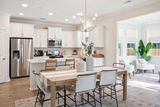 770 Opal Wing St, Moncks Corner, SC 29461 - kitchen featuring stainless steel appliances, a kitchen island, light wood-type flooring, white cabinetry, and recessed lighting
