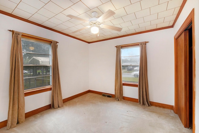 unfurnished room featuring crown molding, light colored carpet, and ceiling fan