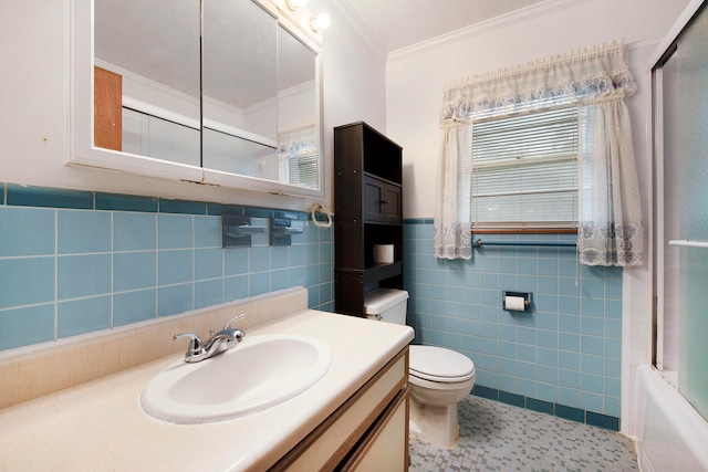 full bathroom featuring crown molding, combined bath / shower with glass door, tile walls, vanity, and toilet