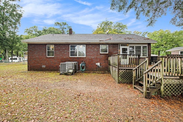 rear view of house featuring a sunroom, cooling unit, and a deck