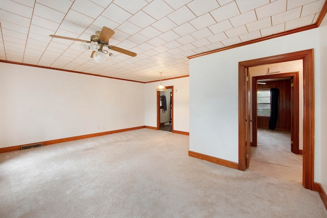 carpeted empty room featuring crown molding and ceiling fan