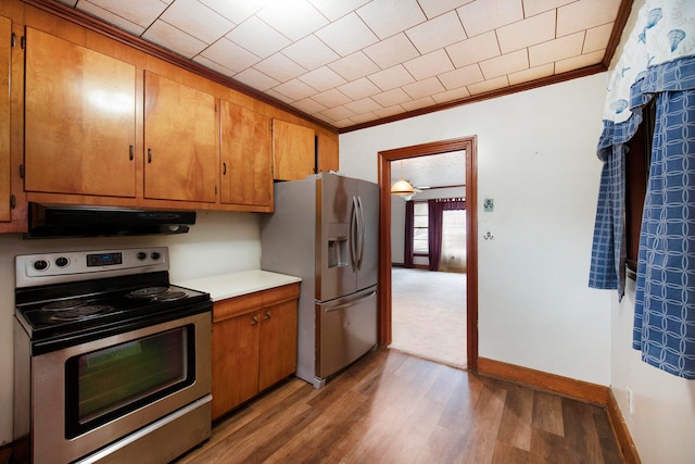 kitchen with ornamental molding, stainless steel appliances, and light wood-type flooring