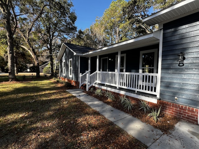 view of home's exterior with a porch and a yard