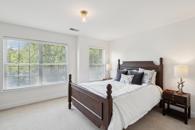 bedroom with light colored carpet, visible vents, and baseboards