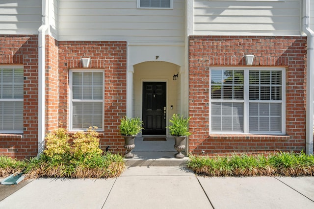 property entrance with brick siding and visible vents