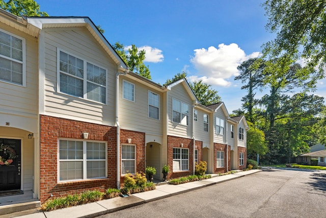 exterior space featuring brick siding and a residential view