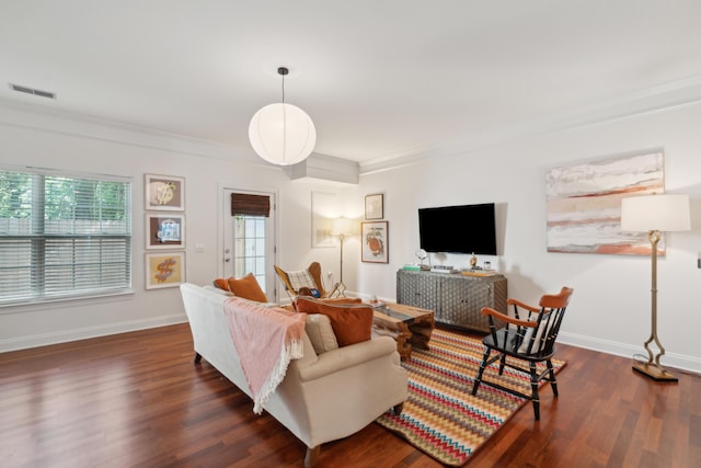 living area featuring ornamental molding, baseboards, visible vents, and dark wood finished floors