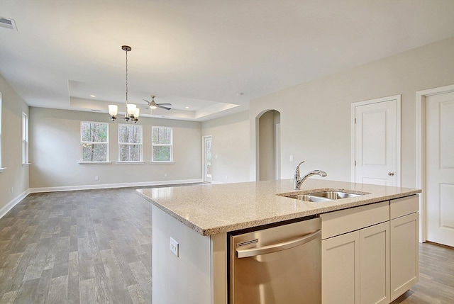 kitchen with dishwasher, light wood-type flooring, a tray ceiling, hanging light fixtures, and a sink