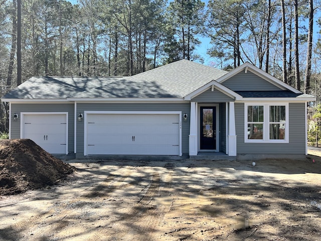 ranch-style house with driveway and a shingled roof